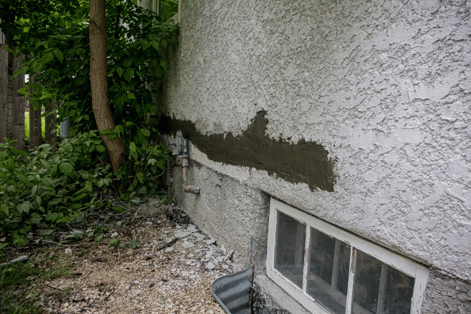 Signs of stucco bubbling and blisters on a wall.