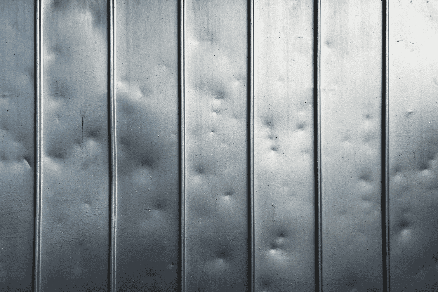 A metal roof showing signs of hail damage, highlighting the effects of hail storms.