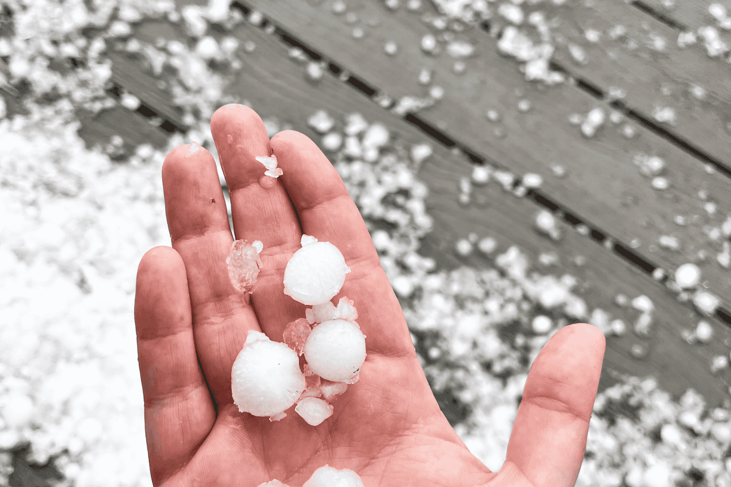 A variety of hail stones of different sizes on a surface, demonstrating how different size hail stones affect roof